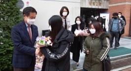 김동원 총장이 격리가 해제돼 생활관을 나오는 유학생들에게 꽃을 전하고 있다.jpg